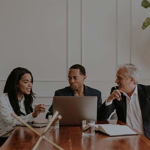 three people in front of laptop looking for solutions and talking