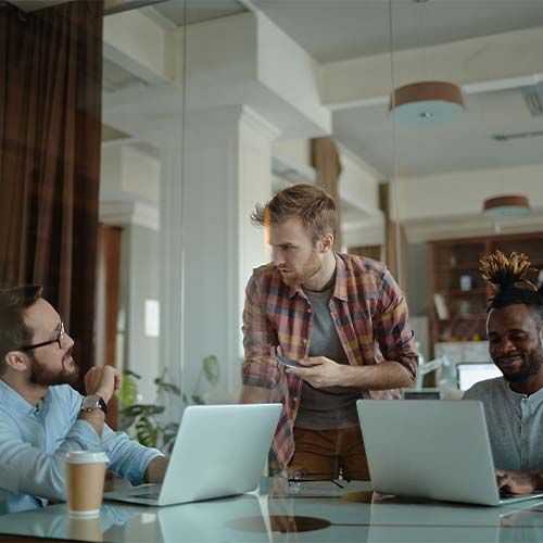 three men talking and holding cup of coffee