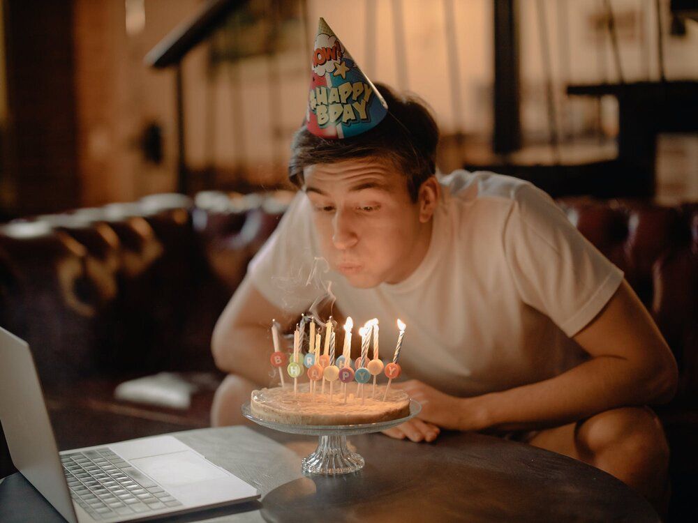 man blowing out birthday candles
