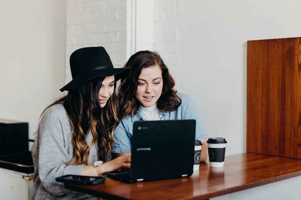 two young women watching laptop